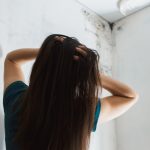 Shocked Woman Looking At Mould Wall